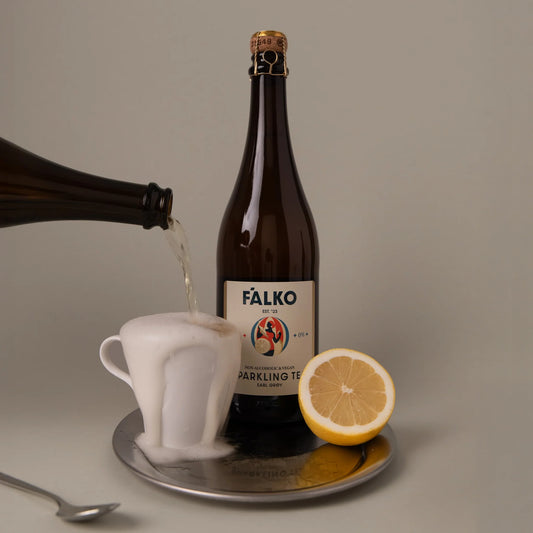 Falko Sparkling Tea gėrimas šalia sūrių rinkinio ir jūros gėrybių